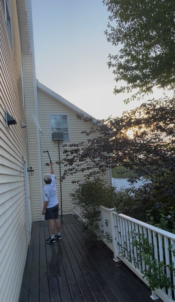 Flannery team member power washing a residential deck